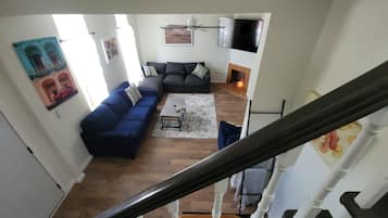 A living room with a dark blue sofa, a coffee table, and a fireplace.