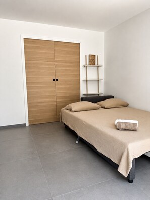 Ein Schlafzimmer mit einem Bett, einem Kleiderschrank und einer Regaleinheit.
