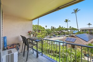 A balcony with a view of a residential area, including houses and palm trees. - NEW- Renovated Ocean view- Across from the beach- Fantastic location (Kihei)