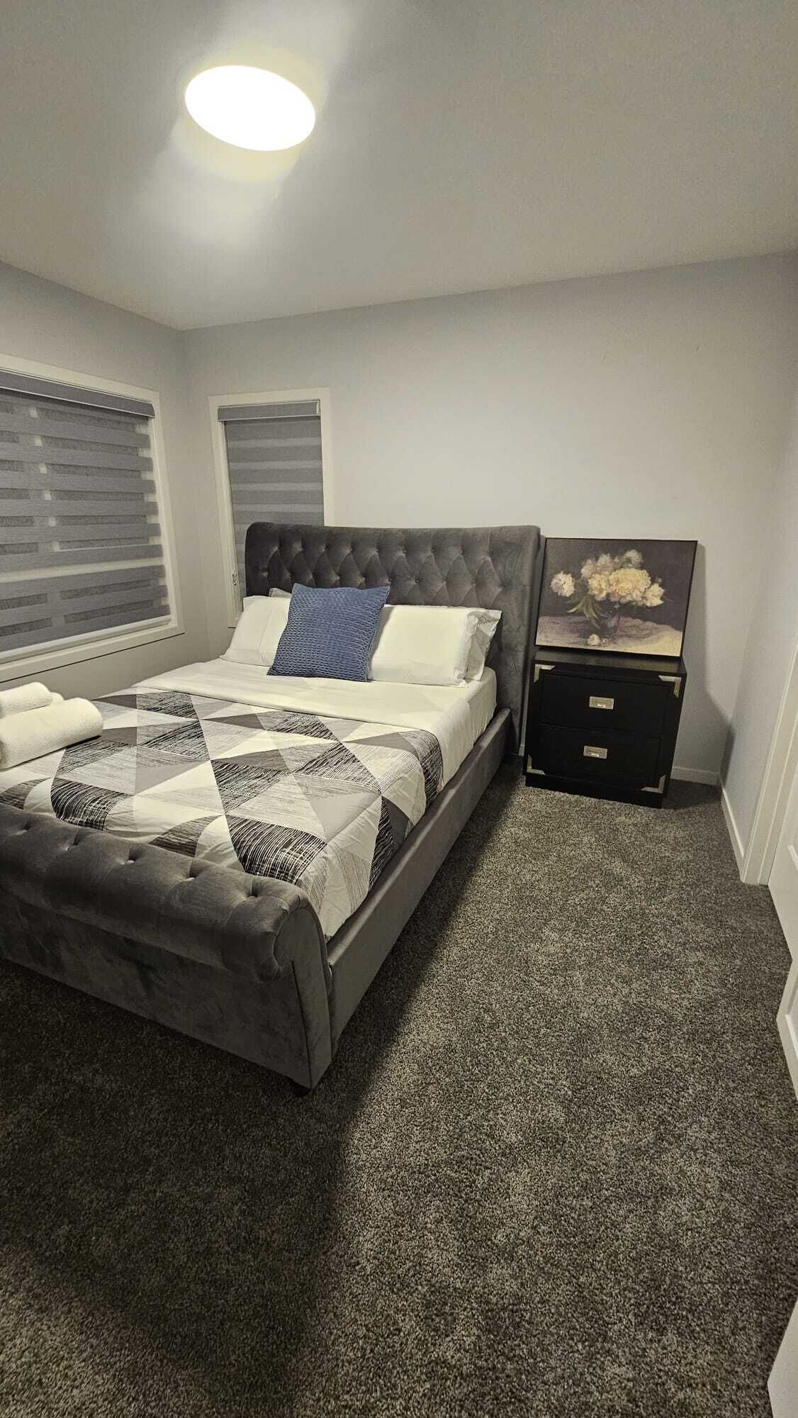A bedroom with a bed, a nightstand, and a wall-mounted cabinet.