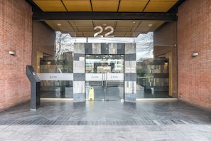 Ein Gebäudeeingang mit Glastür, der Aufschrift '22' über der Tür und einem Schild mit dem Wort 'ICONO'.