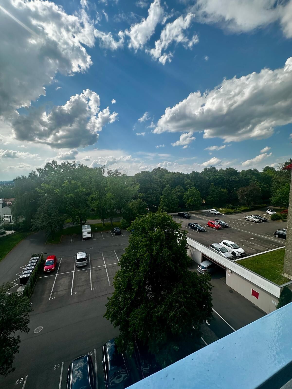 A parking lot with multiple cars and a building in the background.