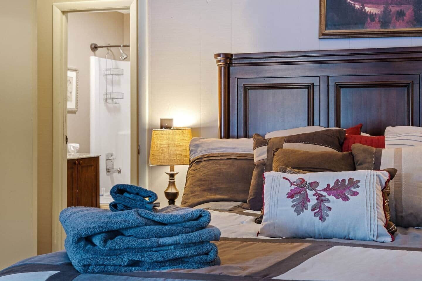 Une chambre d’hôtel avec un lit bien fait, une lampe et une vue sur l’extérieur.