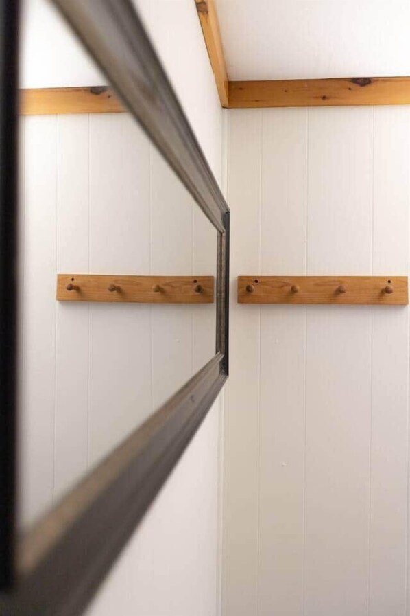 A room with white paneled walls, wooden beams, and two wooden shelves with hooks. - MtSnow* HotTub*  Pool * AirHockey*PingPong * Darts (Wilmington)