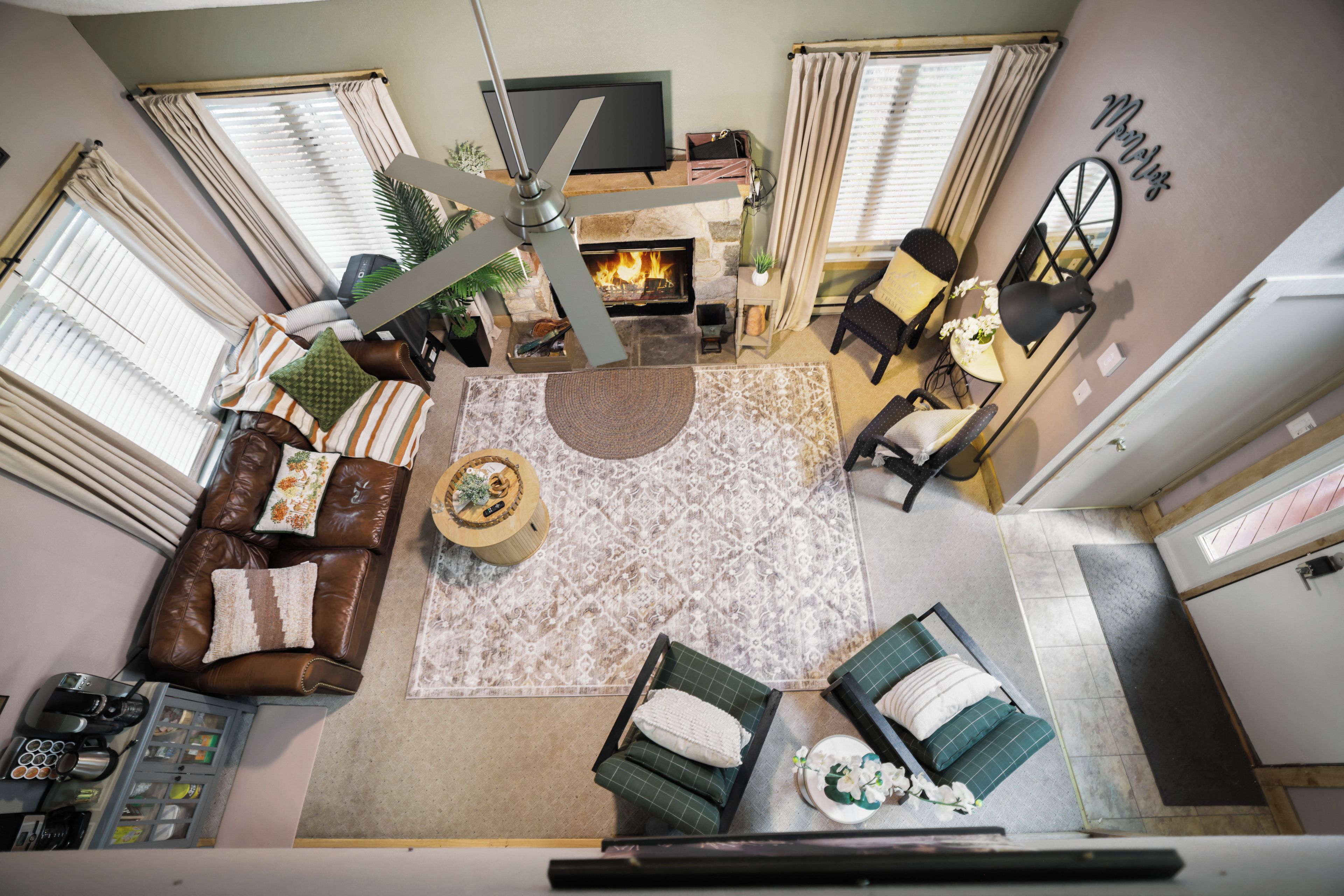 A spacious living area with a fireplace, a sofa set, a coffee table, and a dining area.