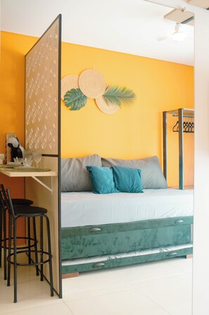 A room with a bed, a desk, and a chair.