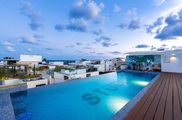 A rooftop swimming pool with a view of the cityscape and the sea. - Modern Apartment Pool & Balcony (Playa del Carmen)