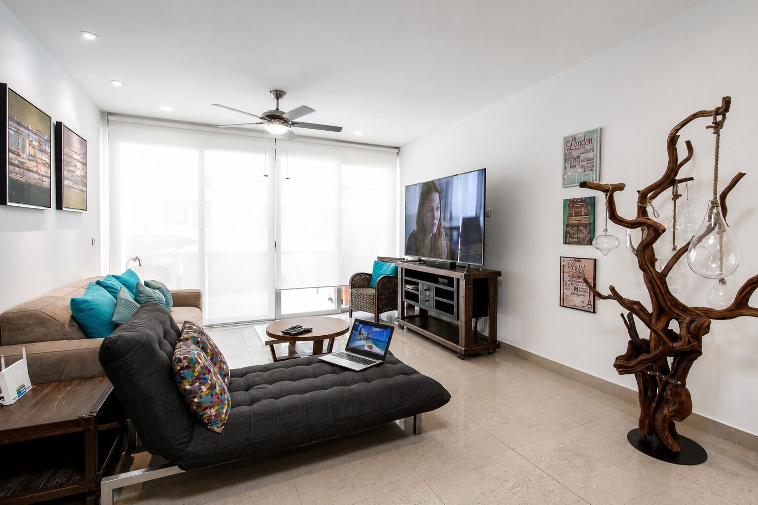 A modern living room with a sofa, a coffee table, a TV, and a decorative wooden sculpture.
