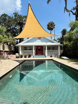 A house with a swimming pool, a red door, and a covered porch. - Gorgeous Hideaway w/pool in Historic Downtown NSB (New Smyrna Beach)