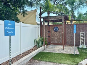A gated entrance with a sign reading 'The Hideaway Guests' and a decorative wooden gate. - Gorgeous Hideaway w/pool in Historic Downtown NSB (New Smyrna Beach)