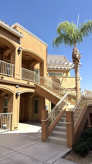 A multi-story building with a balcony, a palm tree, and a staircase. - Walking distance from the World Famous, Indian Wells Tennis Gardens (La Quinta)