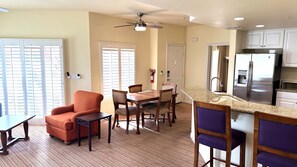 A modern kitchen with a built-in refrigerator, a dining area with a table and chairs, and a ceiling fan. - Walking distance from the World Famous, Indian Wells Tennis Gardens (La Quinta)