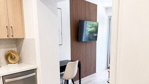 A modern kitchen with wooden cabinets, a dishwasher, and a dining area with a table and chairs.