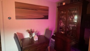 Ein Essbereich mit Holztisch und -stühlen, einem Wandbild und einer Vitrine.