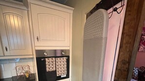 A compact kitchen with white cabinetry, a stainless steel refrigerator, and a black countertop. - Cozy 1 bedroomed apartment in Clackmannanshire (Coalsnaughton)