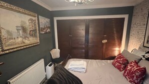 Ein Hotelzimmer mit einem Bett, einem Heizkörper, einem Stuhl, einem Bild und einer Tür mit der Aufschrift 'PRIVATE'.