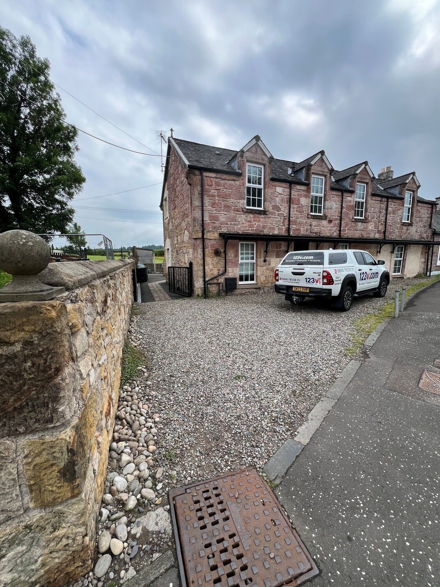 A stone building with a parked vehicle in front.