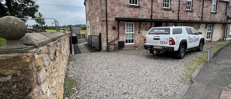 Un bâtiment en pierre avec un véhicule garé devant.