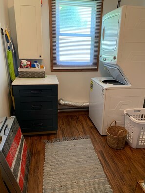 A laundry room with a washing machine, dryer, and a cabinet with cleaning supplies.