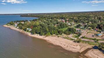 Zona residencial costera con casas, una playa y una extensión de agua.