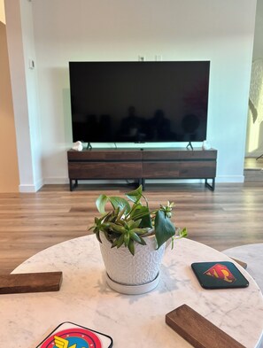 A living room with a television, a coffee table, and a potted plant. - New House W/ Rooftop Near DTLA, Dodgers, Universal, Griffith Park. Great price! (Los Angeles)