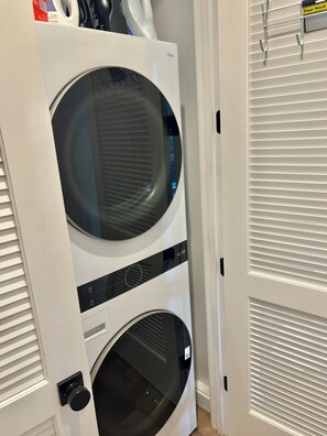 A front view of a stacked washer and dryer unit with a control panel and a door handle. - New House W/ Rooftop Near DTLA, Dodgers, Universal, Griffith Park. Great price! (Los Angeles)