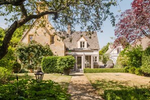 Ein traditionelles Steinhaus mit einem Gartenweg, der zum Eingang führt.