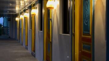 A corridor with doors, each with a light fixture above.