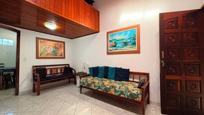 Ein Zimmer mit einer hölzernen Bank, einem Sofa mit floralem Bezug und einer Tür im traditionellen Stil.