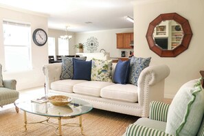 A living room with a sofa, a glass coffee table, and striped chairs. - 3-BD/2.5-BA Charming Getaway, Only 10 mins to DT! (Houston)