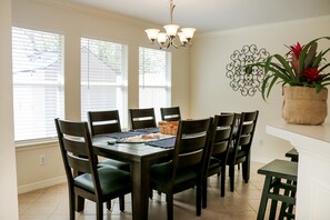 A dining area with a dark wooden table, six chairs, and a chandelier. - 3-BD/2.5-BA Charming Getaway, Only 10 mins to DT! (Houston)