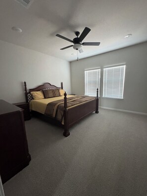 A bedroom with a four-poster bed, a ceiling fan, and two windows with blinds. - Modern Georgetown Escape - A brand-new home base in the heart of Georgetown (Georgetown)