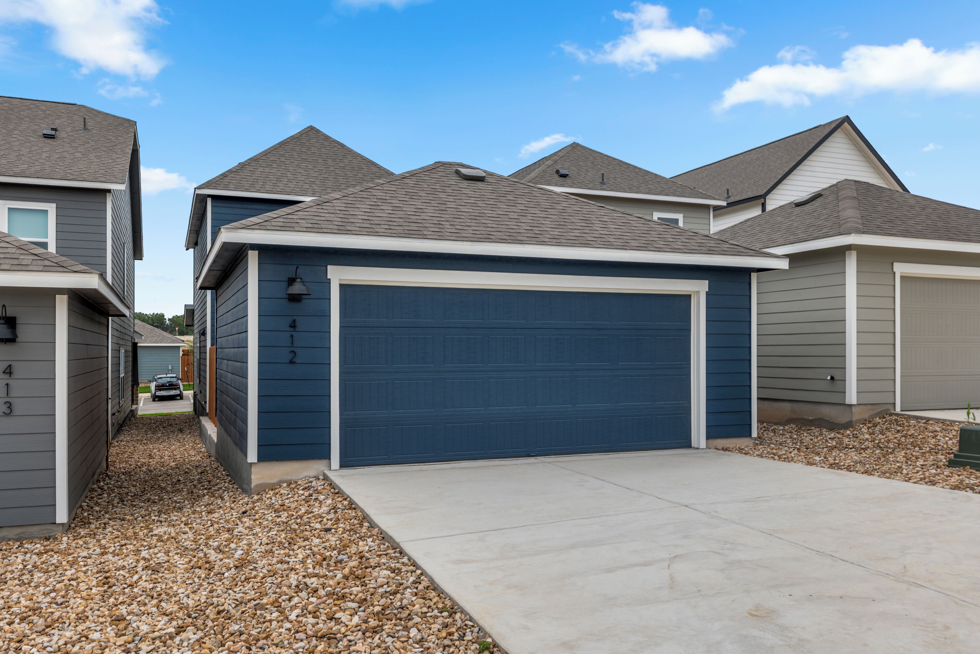 A residential area with houses featuring gabled roofs and a garage door.