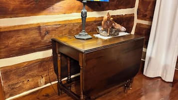 Un tavolo in legno con una lampada in vetro colorato e una scultura in legno.