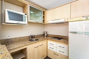 A kitchen with a microwave, stove, refrigerator, and granite countertop. - Suite W/beautiful View in Resort in Jurere Jbv252 (Florianópolis)
