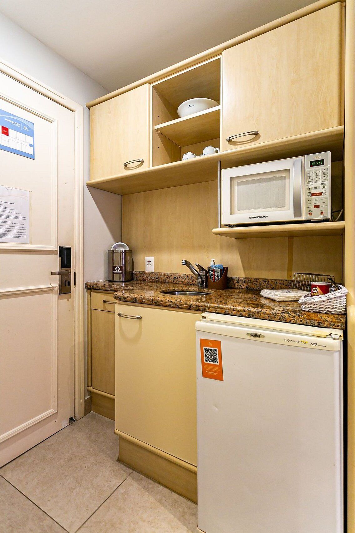 A compact kitchenette with a microwave, a coffee maker, and a refrigerator.