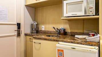 A compact kitchenette with a microwave, a coffee maker, and a refrigerator.