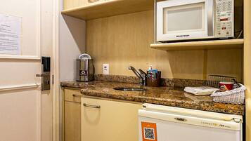 A compact kitchenette with a microwave, a coffee maker, and a refrigerator.