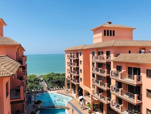 Ein Hotel mit Pool, Balkonen und Meerblick.