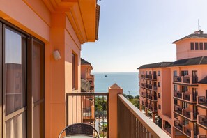 Uma varanda com vista para o mar e edifícios próximos.
