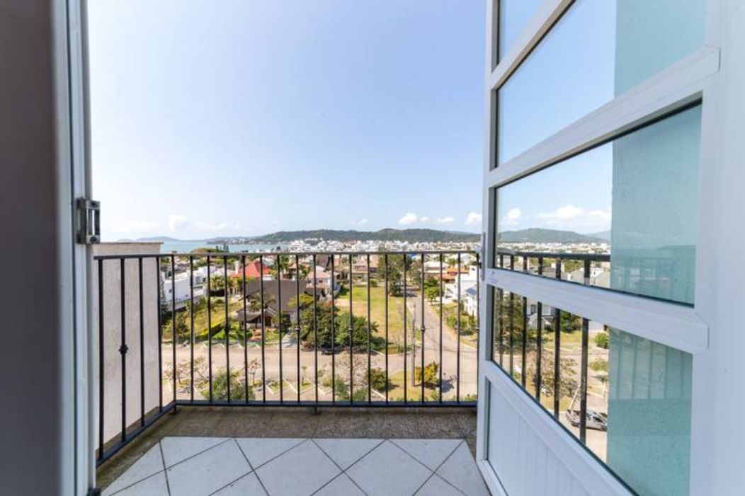 Varanda com vista para uma área residencial e colinas ao longe.