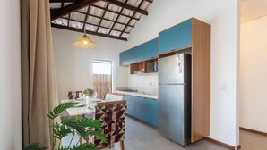 Una cucina moderna con mobili azzurri, un frigorifero in acciaio inossidabile e un'area pranzo con un tavolo apparecchiato per due.