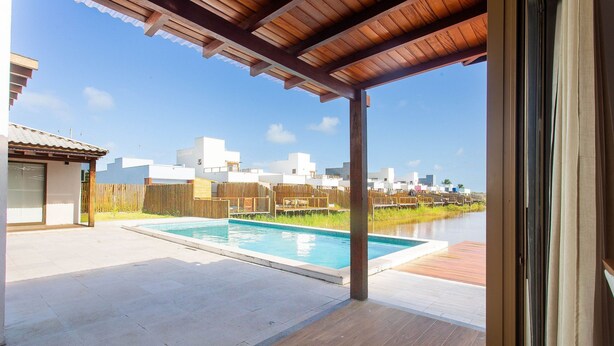 Un'area esterna coperta con piscina, terrazza in legno e vista sulla città.