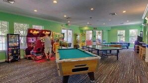 A recreational room with pool tables, arcade games, and a carpeted floor. - Beautiful Condo at Windsor Palms Resort (Kissimmee)