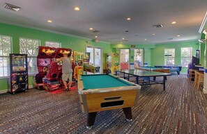 A recreational room with pool tables, arcade games, and a carpeted floor. - Beautiful Condo at Windsor Palms Resort (Kissimmee)