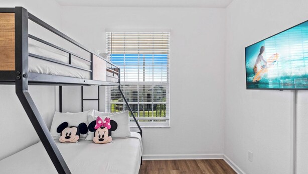 A room with a bunk bed, a window with blinds, and a flat-screen TV on the wall. - Beautiful Condo at Windsor Palms Resort (Kissimmee)