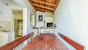 A narrow corridor with a wooden bench, a brick fireplace, and a kitchen area with a microwave. - House With Pool in Cond 150m Beach Mariscal Ccm004 (Bombinhas)