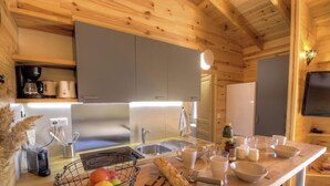 Una cocina moderna con armarios grises, un lavamanos de acero inoxidable y una encimera de madera.
