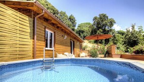 A wooden cabin with a swimming pool, outdoor seating, and a patio area. - U Cucciu - OCANA - Vacation Rental (OCANA)