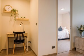 A room with a desk, chair, and a bed with pillows. - Beautiful Apt in Las Condes with Pool (Las Condes)